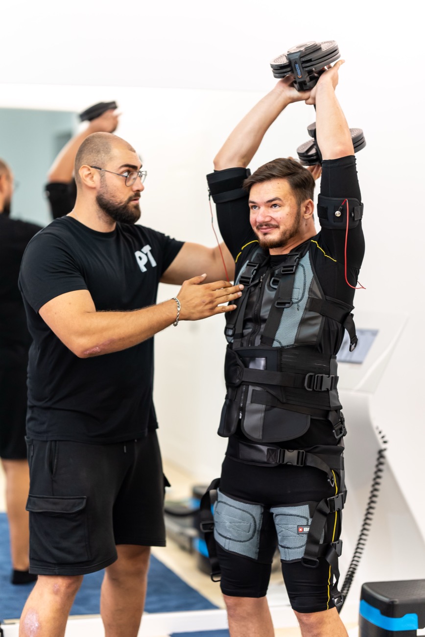 Antrenor BuzzFit reglând costumul EMS X-Body